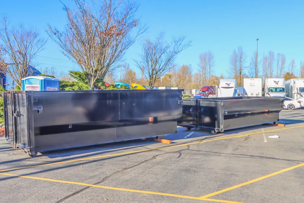 Professional dumpster rental service with roll-off container on residential driveway in Houghton